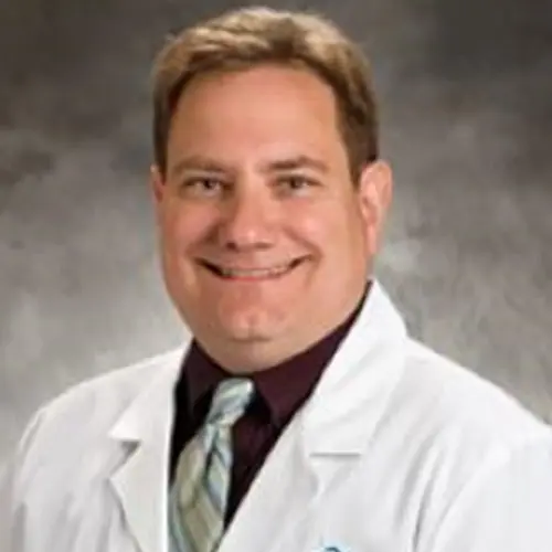 A man in white lab coat and tie.