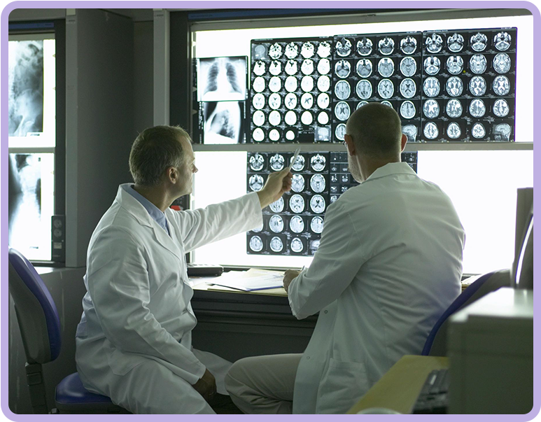 Two doctors are looking at a display of mri scans.