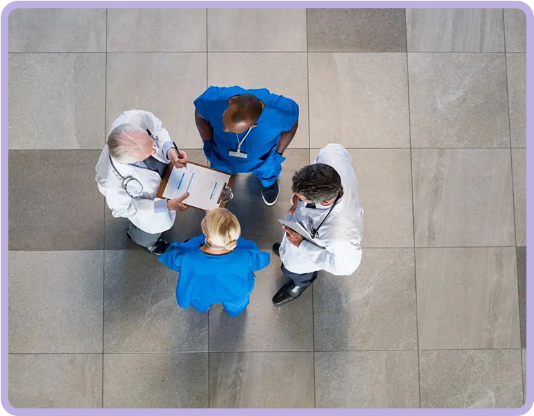 Four doctors are standing in a group on the floor.