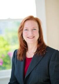 A woman in a suit and red shirt